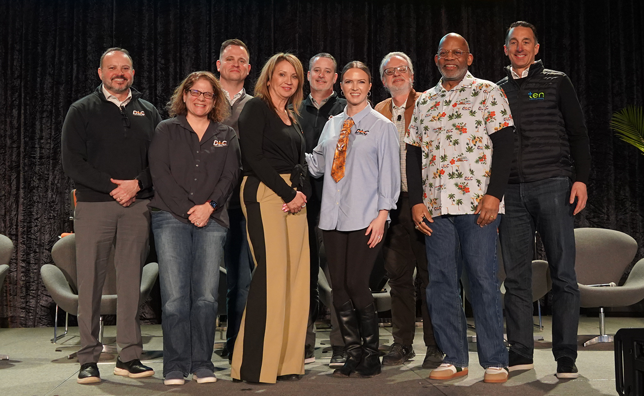 DLC executive leadership team smiling on stage