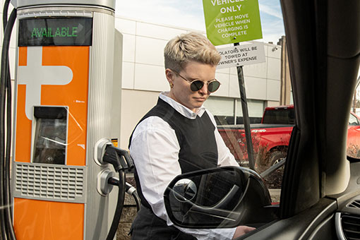 person charging an electric vehicle