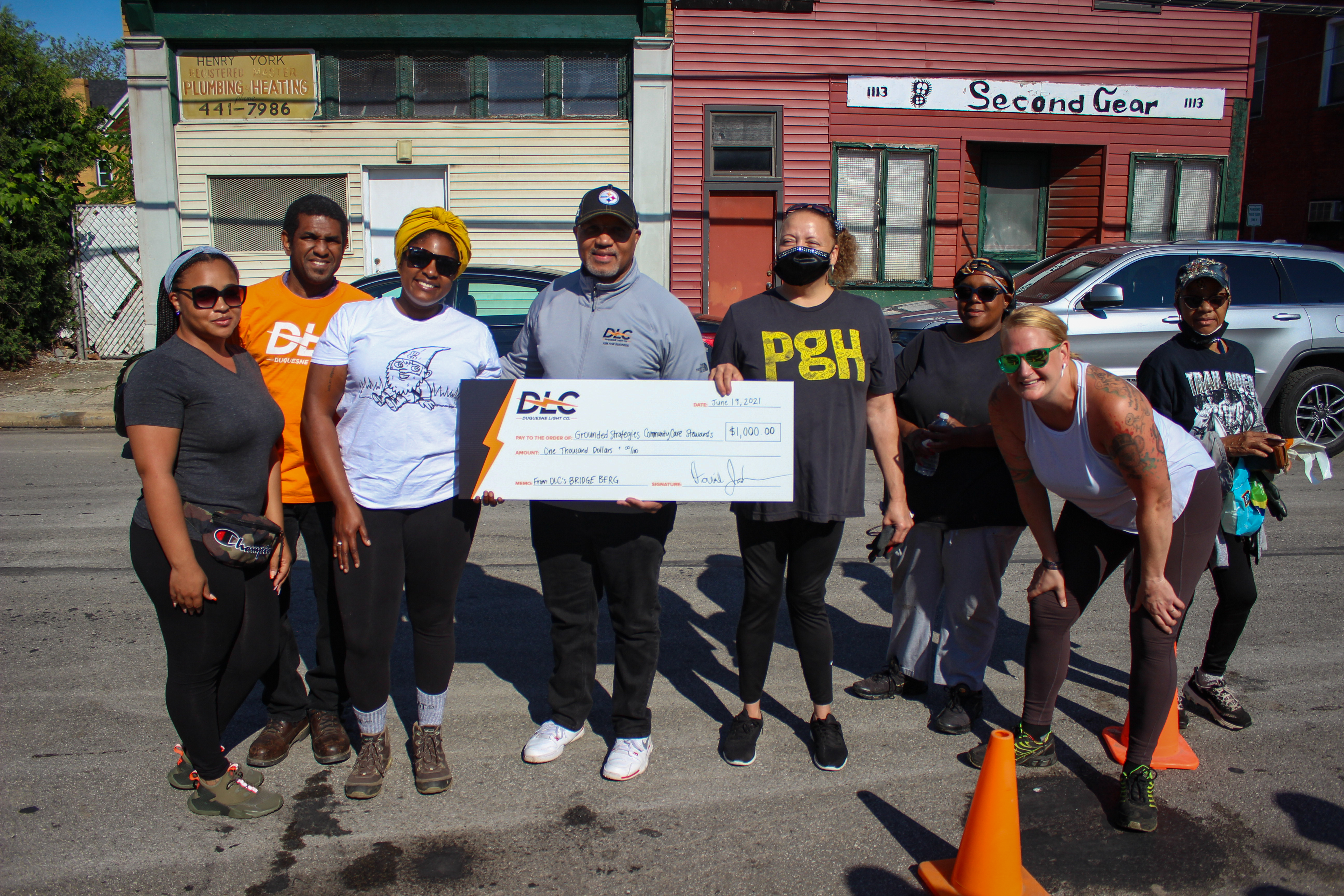 Duquesne Light President & CEO Kevin Walker poses with members of Grounded Strategies holding a $10,000 check